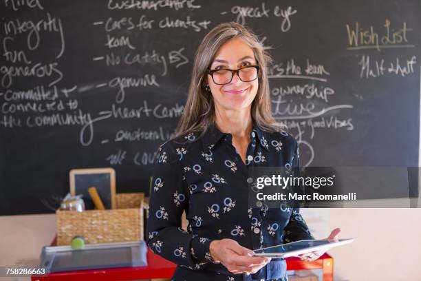 caucasian teacher using digital tablet in classroom - blackboard women stock pictures, royalty-free photos & images