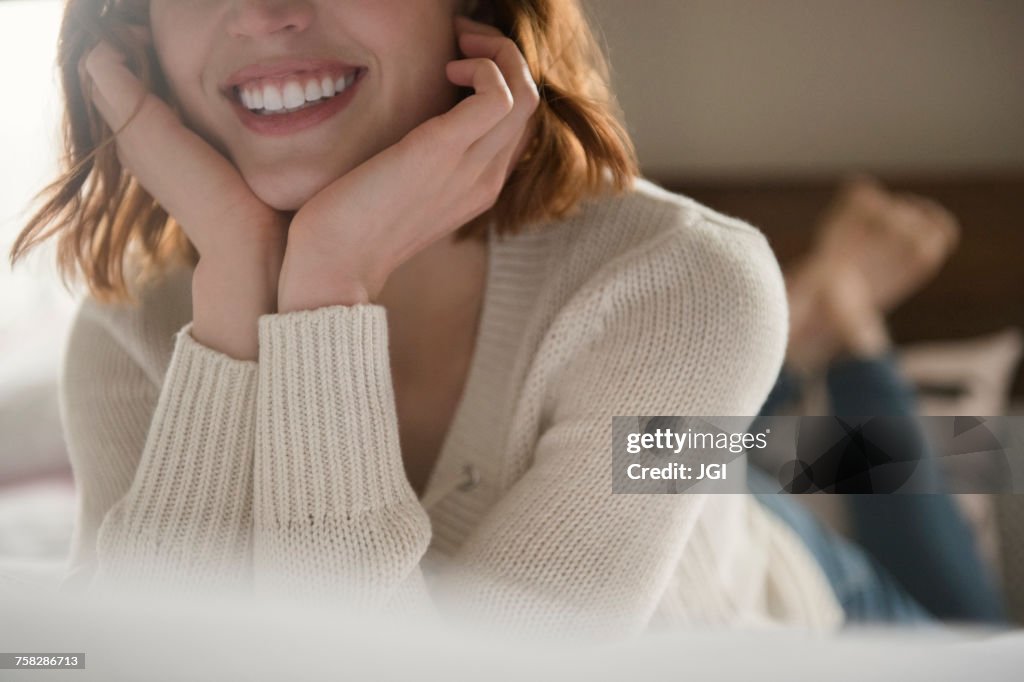 Caucasian woman laying on bed with head in hands