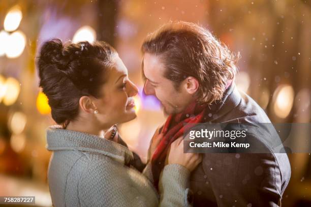 caucasian couple hugging outdoors at night - woman snow outside night stockfoto's en -beelden