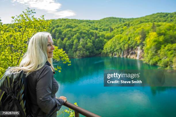 older caucasian woman admiring scenic view - plitvice stock-fotos und bilder