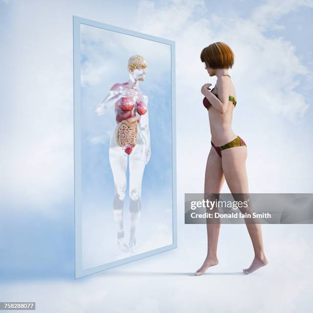 woman examining reflection of organs in virtual mirror - woman-looking-into-mirror-full-body stock pictures, royalty-free photos & images
