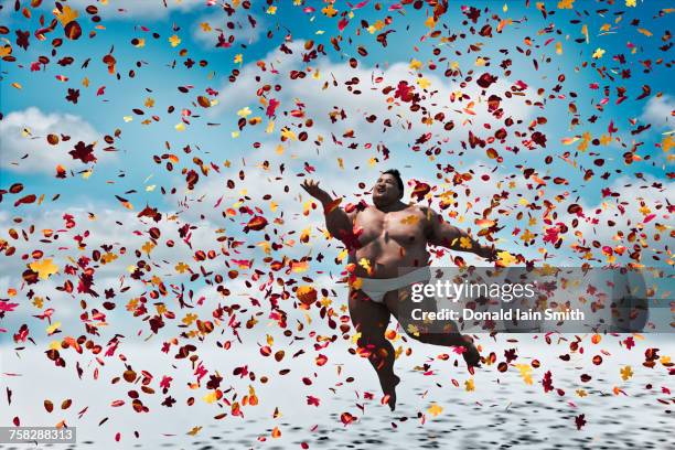 sumo wrestler floating in autumn leaves - sumô - fotografias e filmes do acervo