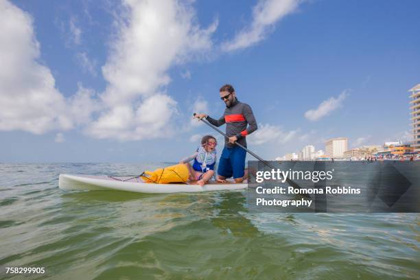 father and daughter paddle boarding in the gulf of mexico, florida, usa - beach florida family stockfoto's en -beelden