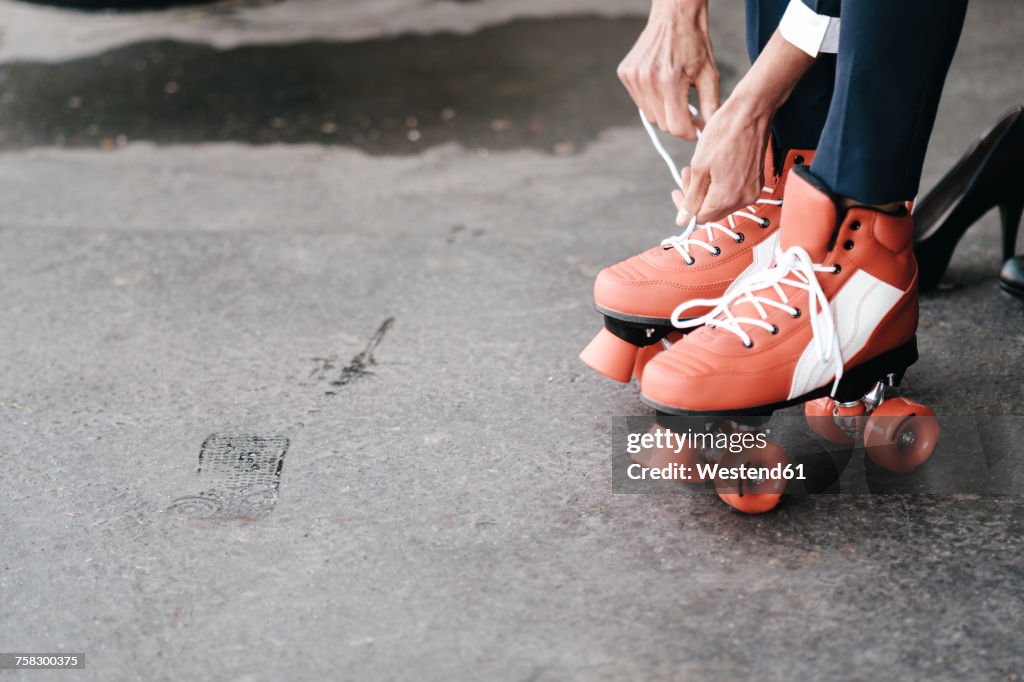 Businesswoman tying her roller skates, close up