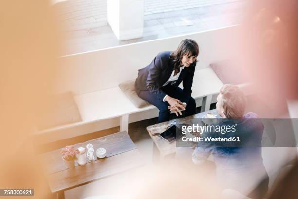 businesswoman having a meeting with client in a cafe - business meeting coffee stock pictures, royalty-free photos & images