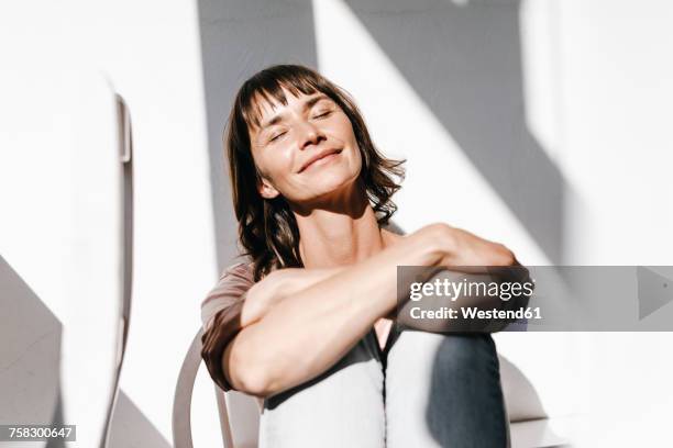 woman enjoying the sun with closed eyes - hot older women fotografías e imágenes de stock