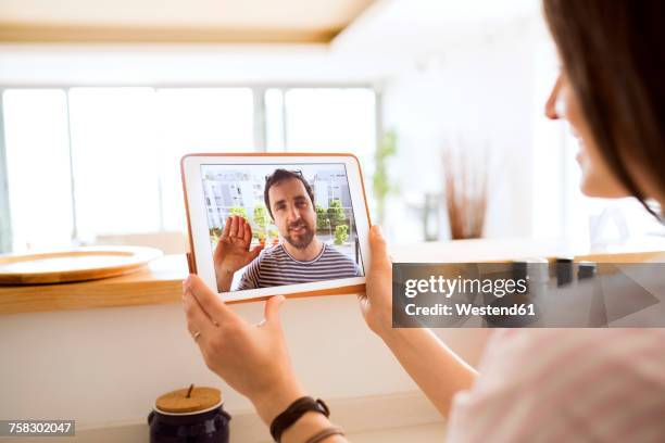 young woman using tablet for video chat at home - relazione a distanza foto e immagini stock