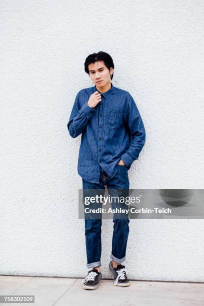 portrait of young man outdoors, wearing jeans and denim shirt - denimhemd stock-fotos und bilder