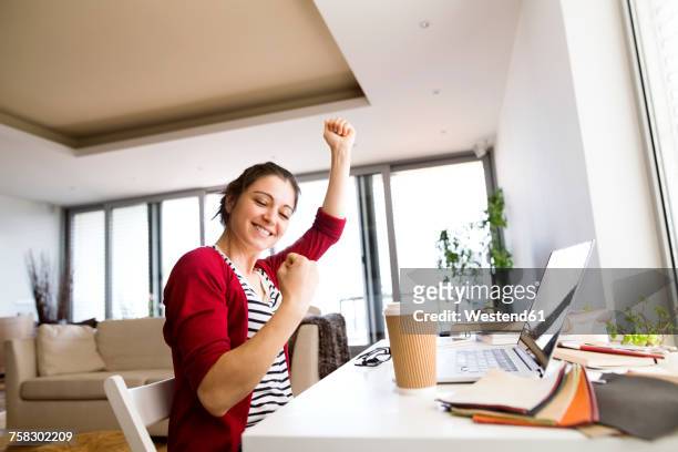 happy woman at desk at home - woman happy raised arms closed eyes stock pictures, royalty-free photos & images