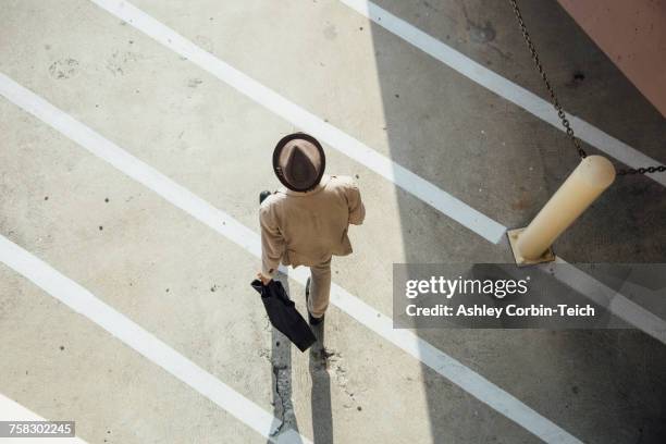 young man walking across road, overhead view - sombrero fedora fotografías e imágenes de stock
