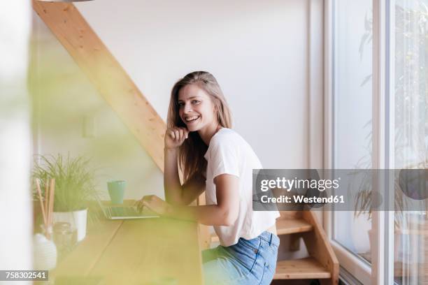 young woman at home using laptop - german blonde stock pictures, royalty-free photos & images