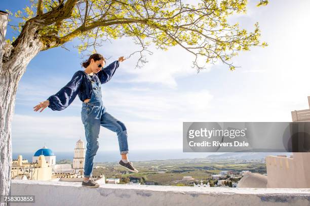 girl balancing on top of wall, oa, santorini, kikladhes, greece - greek independence day stockfoto's en -beelden