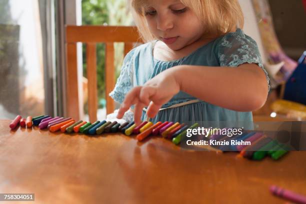 girl lining up crayons in a row - autismus stock-fotos und bilder