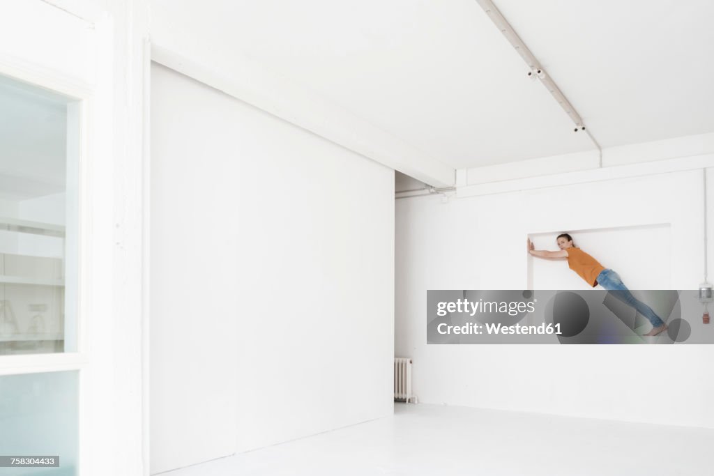 Woman doing gymnastics in niche of a loft