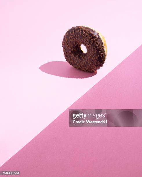 doughnut with chocolate icing on pink ground - at the edge of stock illustrations