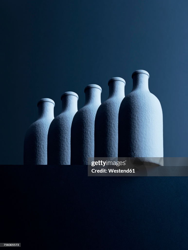 Row of five bottles in front of dark background, 3D-Rendering