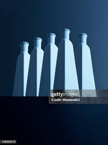 five bottles in front of dark background, 3d-rendering - high contrast stock illustrations