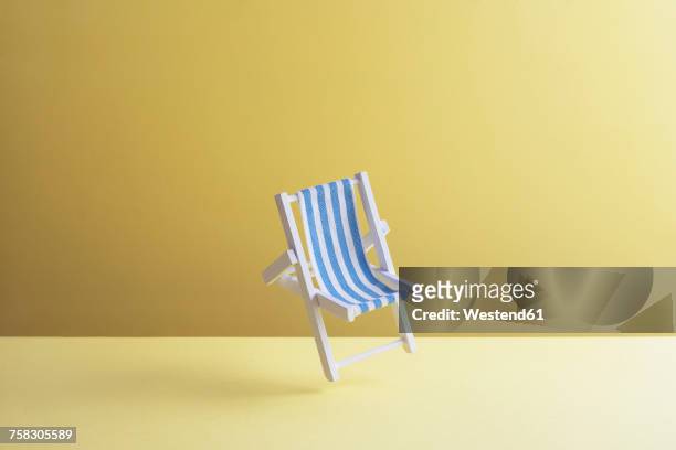 single beach chair hovering in the air in front of yellow ground, 3d rendering - hochgefühl stock-grafiken, -clipart, -cartoons und -symbole