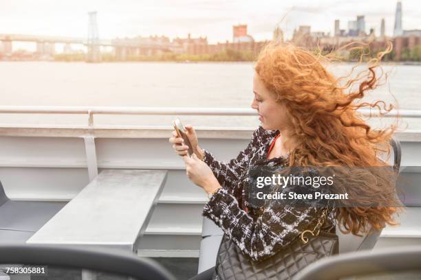 young businesswoman on passenger ferry deck looking at smartphone - commuter ferry stock pictures, royalty-free photos & images