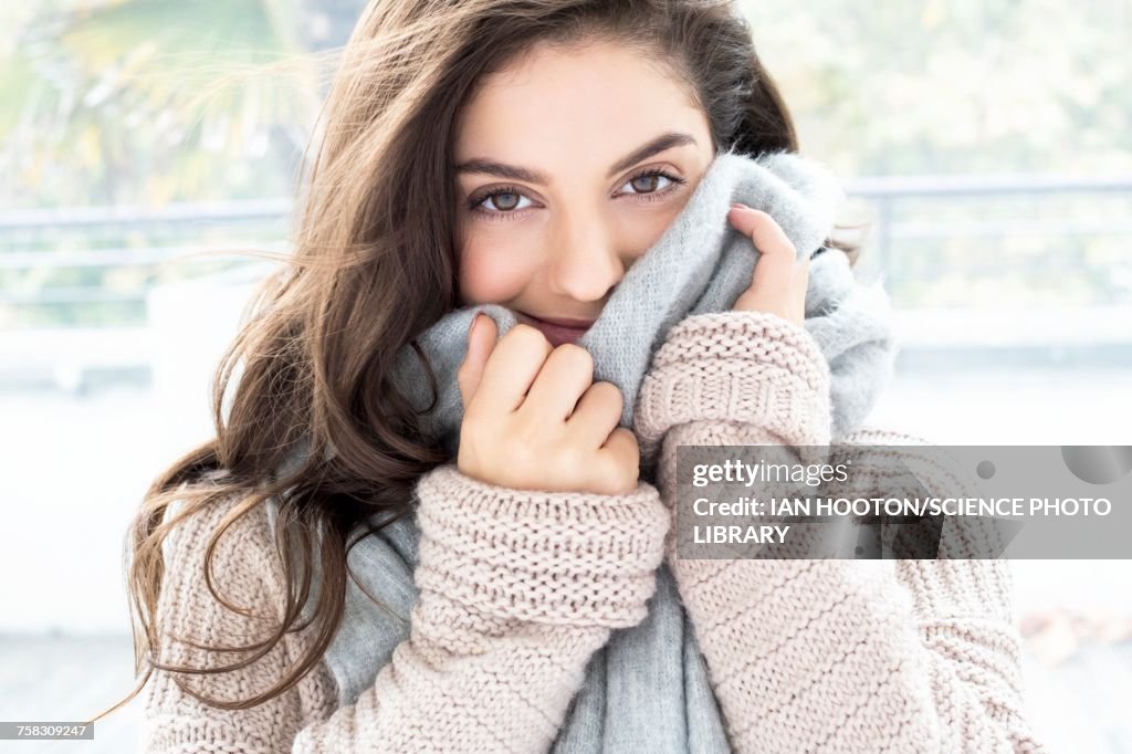 Woman wearing knitted sweater and scarf