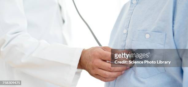 male doctor using stethoscope - hand on chest stock-fotos und bilder