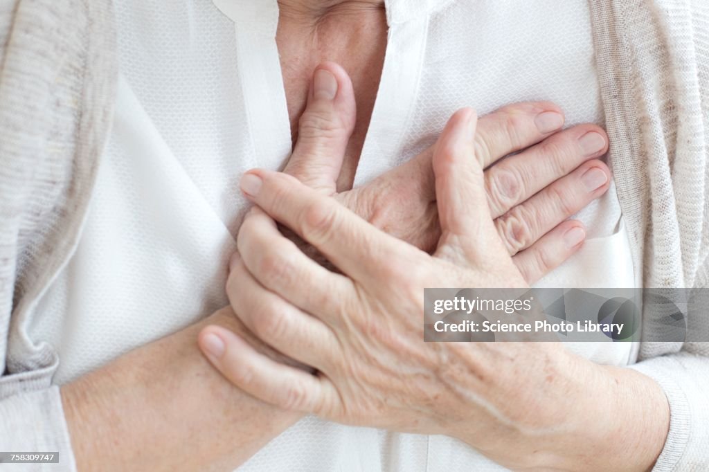 Senior woman holding chest