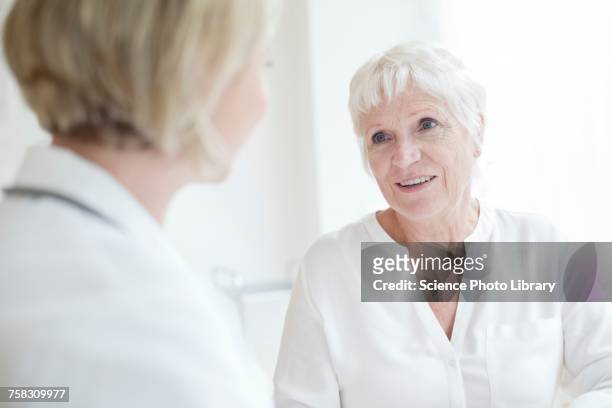 senior woman listening to female doctor - 女性患者 ストックフォトと画像