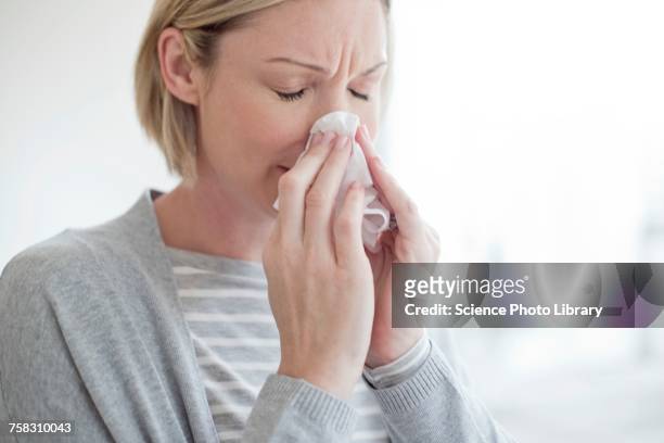 mid adult woman blowing her nose - blowing nose stock pictures, royalty-free photos & images