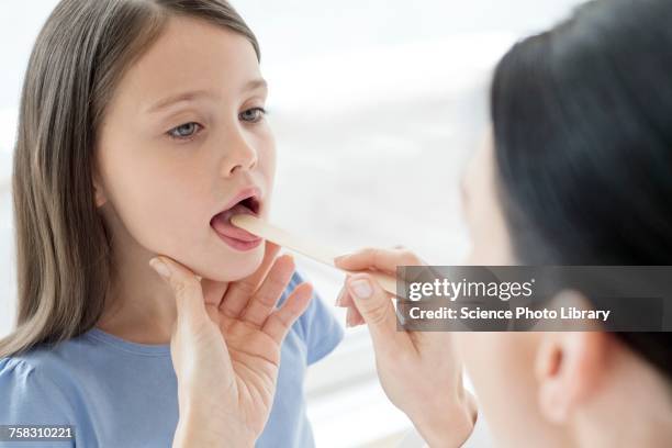 female doctor examining inside girls mouth - girl tongue doctor stockfoto's en -beelden