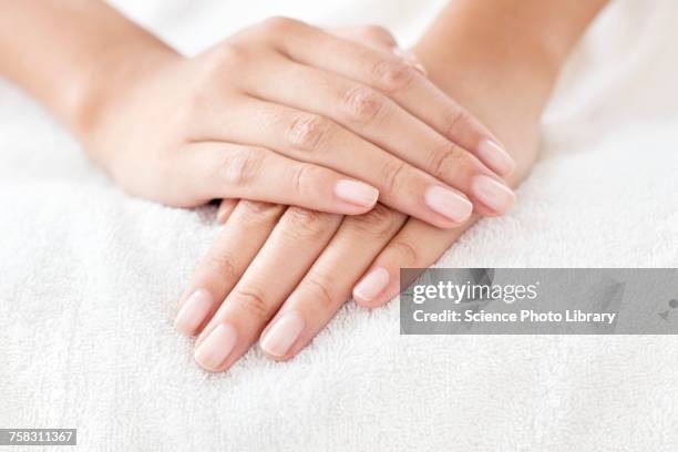 woman with hands resting on white towel - beauty nails stock pictures, royalty-free photos & images