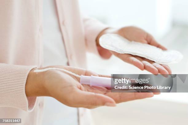 woman holding sanitary towel and tampon - tampon stock pictures, royalty-free photos & images