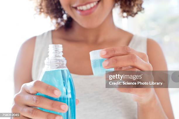 portrait of woman using mouthwash - mundspülung stock-fotos und bilder