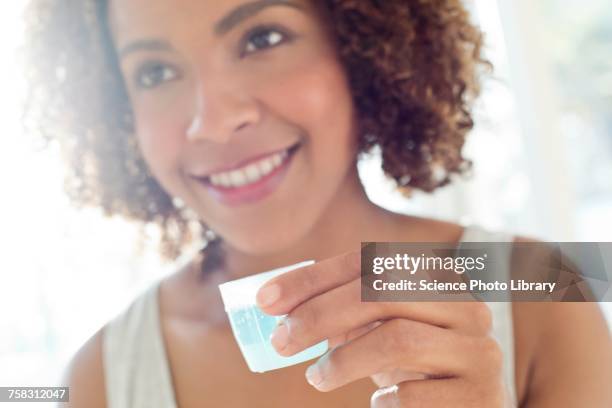 portrait of woman using mouthwash - mouthwash stock-fotos und bilder