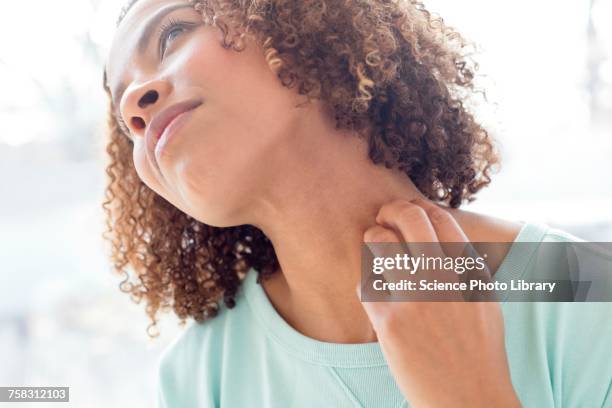 mid adult woman scratching neck - irritation cutanée photos et images de collection