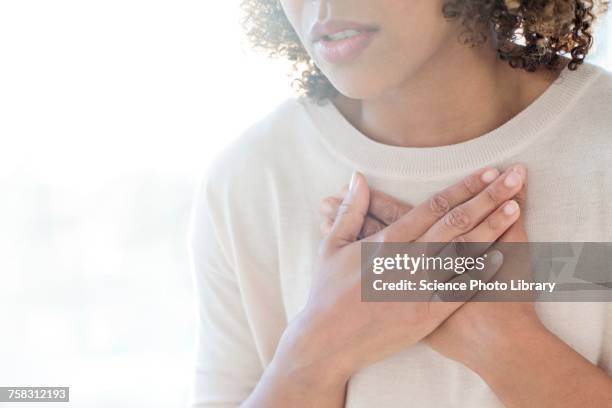 woman touching her chest - asmático fotografías e imágenes de stock