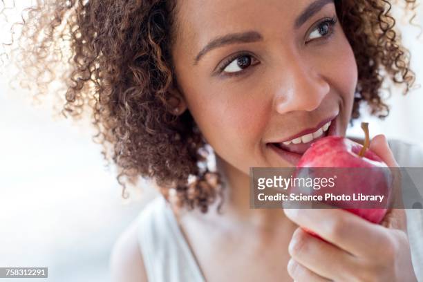 mid adult woman eating apple - apple with bite stock pictures, royalty-free photos & images