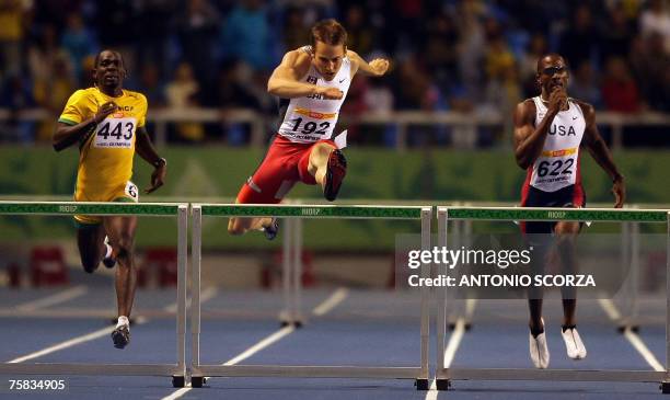 Canadian runner Adam Charles Kunkel jumps ahead of US Laron Bennet and Jamaica's Dean Griffiths, 27 July 2007, during the 400m hurdles final at the...