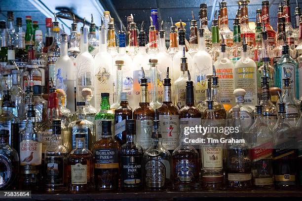 Whiskey and spirit bottles lined up along bar, Georgetown, Washington DC, USA
