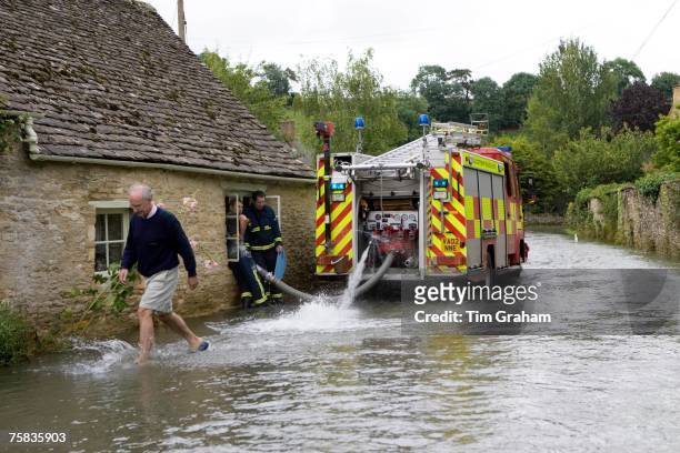 Firemen pump water out of flooded home in Naunton, The Cotswolds, Gloucestershire, England, United Kingdom