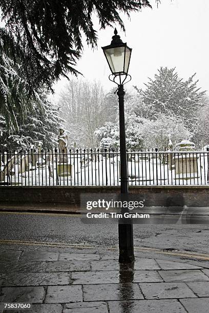 Street lamp besides snow covered graveyard, North London, United Kingdom