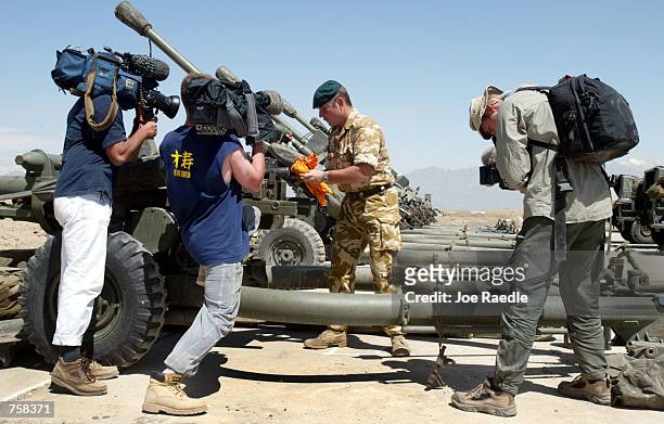 British television crew captures video of Royal Marine Commando Grant Allen from Worcester, England as he cleans a 105mm light field gun April 9,...