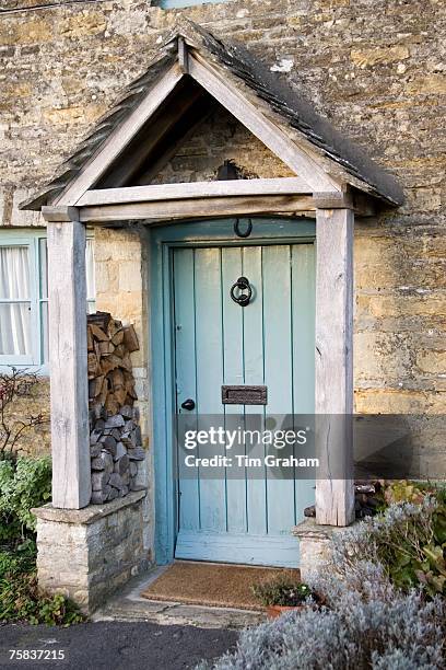 Front door and porch of typical Cotswolds cottage in village in Oxfordshire, England, United Kingdom