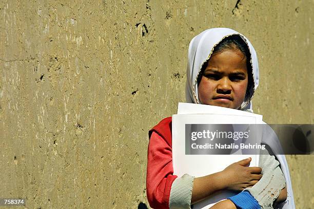 An Afghan schoolgirl holds textbooks given out at the Amir Dost Mohammad Khan Secondary School March 25, 2002 in Kabul, Afghanistan. After six years...