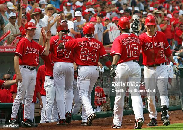 Garret Anderson of the Los Angeles Angels of Anaheim is congratulated by teammates on his way to the dugout after hitting a three run home run in the...