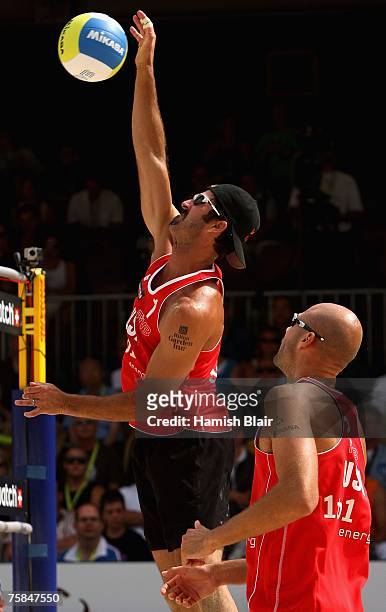 Todd Rogers of USA spikes the ball with team mate Phil Dalhausser looking on during the semi final between Todd Rogers and Phil Dalhausser of USA and...