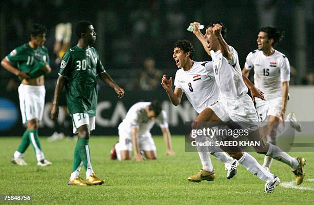 Iraq's captain Younis Mohmoud and teammates run past dejected Saudi Arabia's players as they celebrate their victory at the end of the final match of...