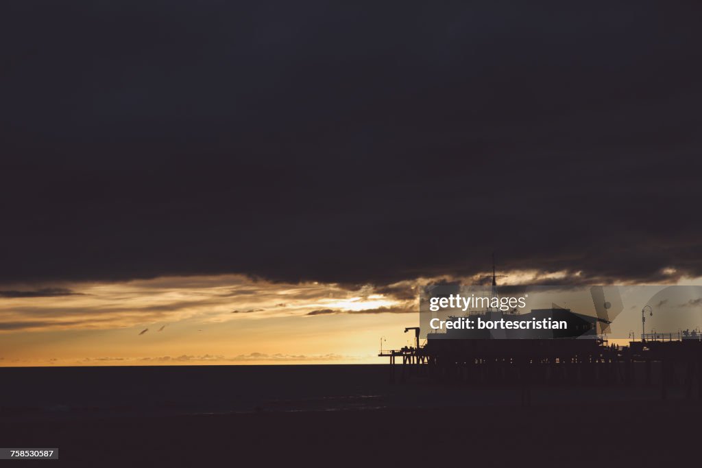 Siluetta del molo di Santa Monica contro il cielo nuvoloso durante il tramonto