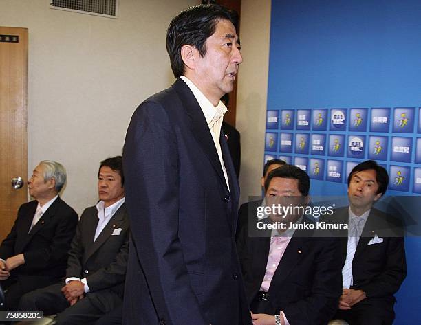 Japanese Prime Minister Shinzo Abe passes by the board members of his Liberal Democratic Party upon his arrival at the press conference at the LDP...