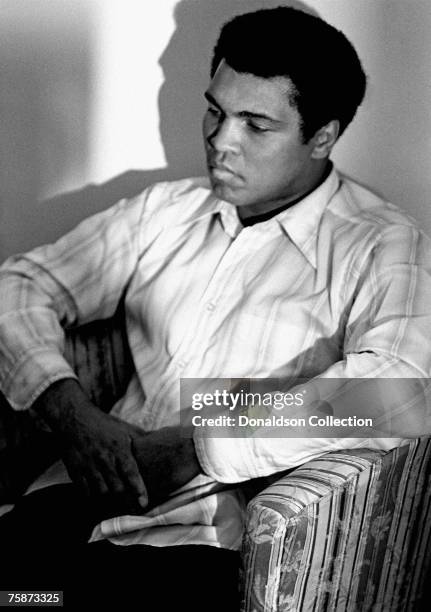 Boxer Muhammad Ali poses during a photo shoot in a hotel room in New York.