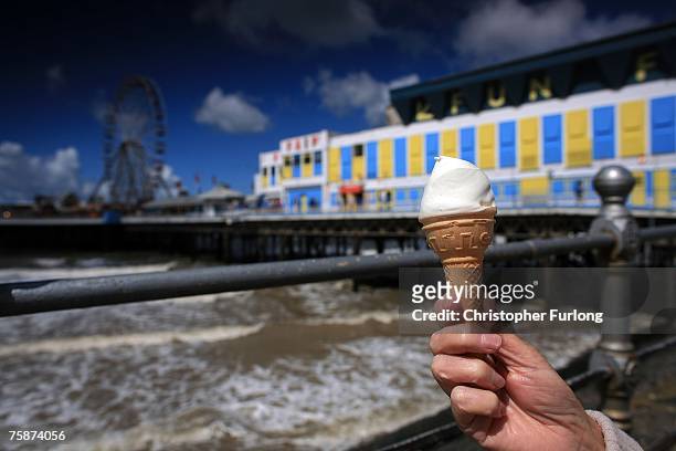 Woman holds her ice cream as holiday makers arrive for the the warm but windy weather on July 30 in Blackpool, England. After the recent floods and...